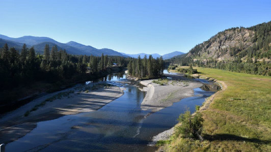 A river flowing between forested hills