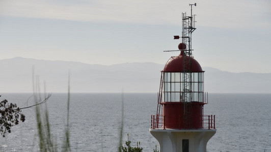 A lighthouse with the ocean in the background.