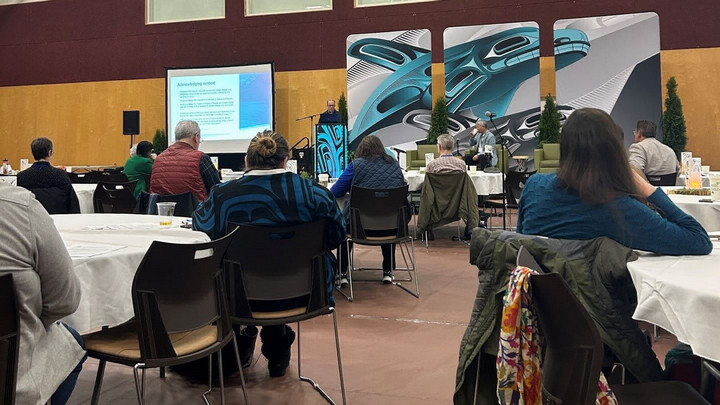 Photo of a presentation and the audience taken from the back of the room